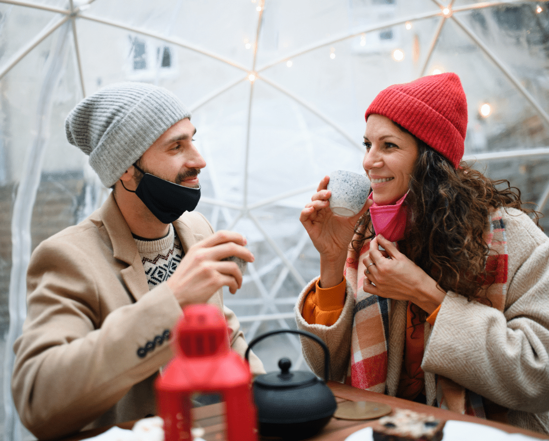 winter promotions ideas for restaurants by grubhub; a couple enjoying coffee inside an igloo