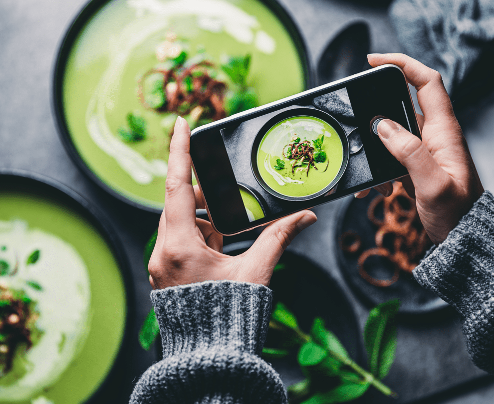 a restaurant owner taking a menu photo using food photography tips from Grubhub