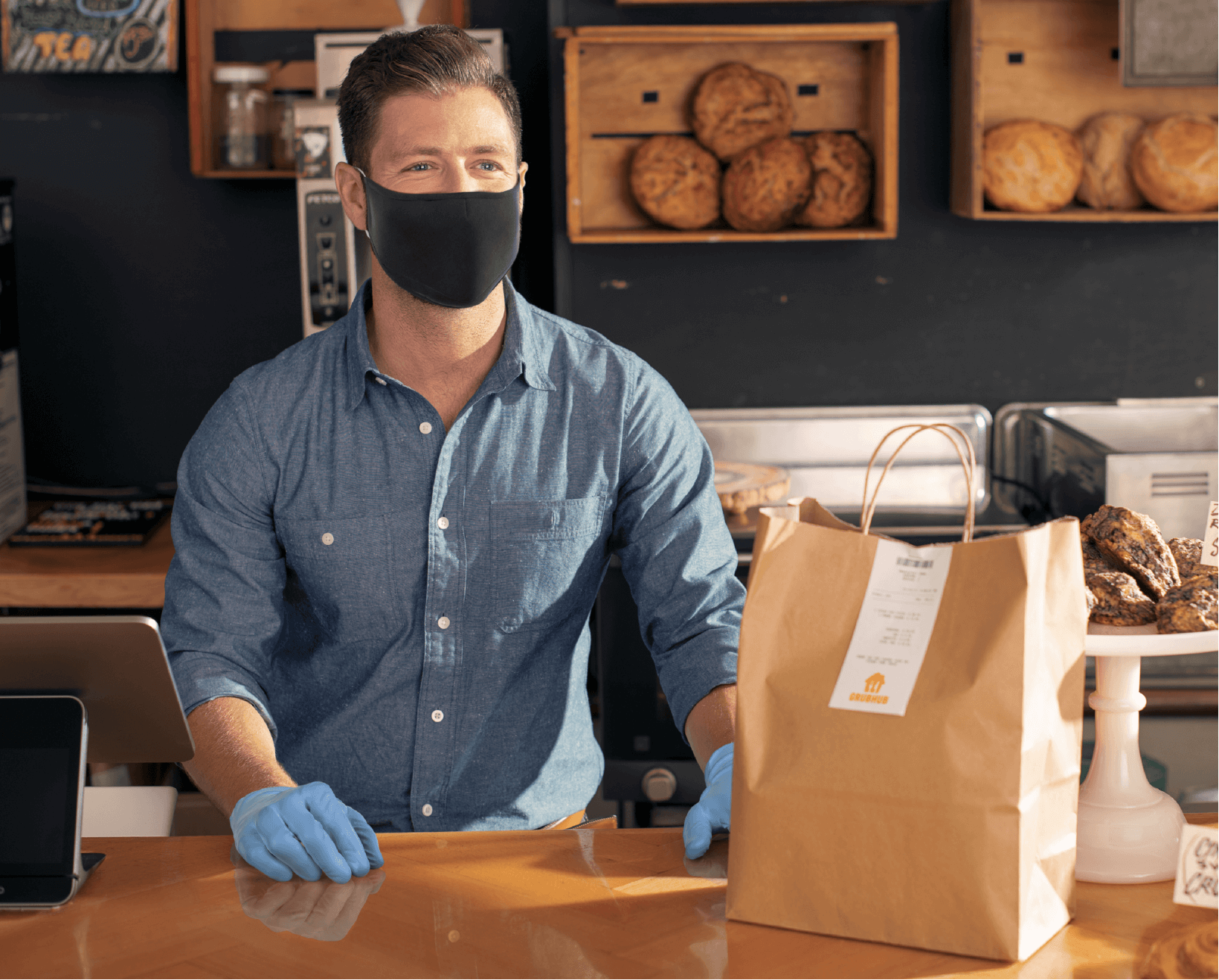 man in a mask at a restaurant counter