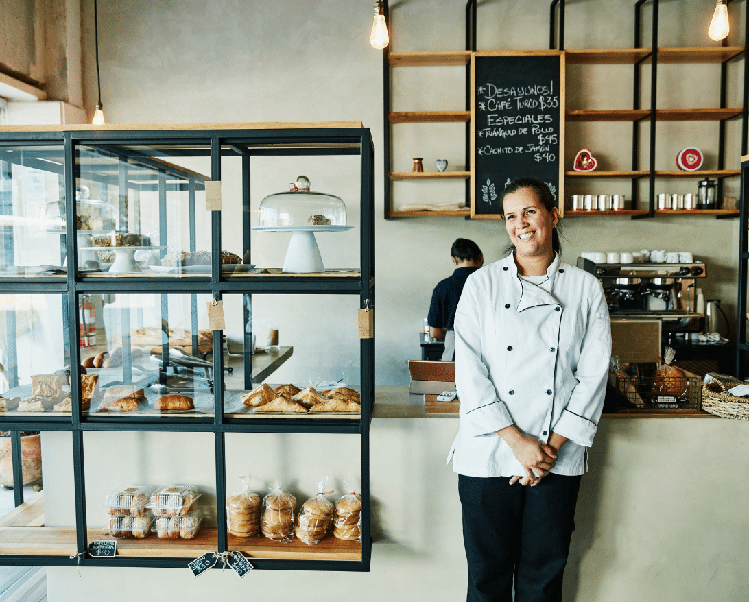 restaurant owner leaning against her bakery items displayed