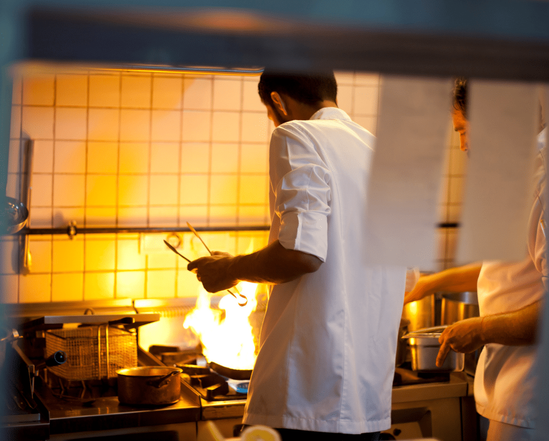 chef working behind the scenes in a pop up kitchen with fire on the stove