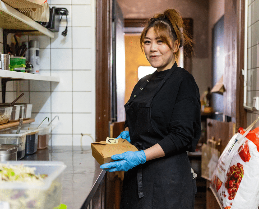 woman packing food delivery orders in the restaurant kitchen