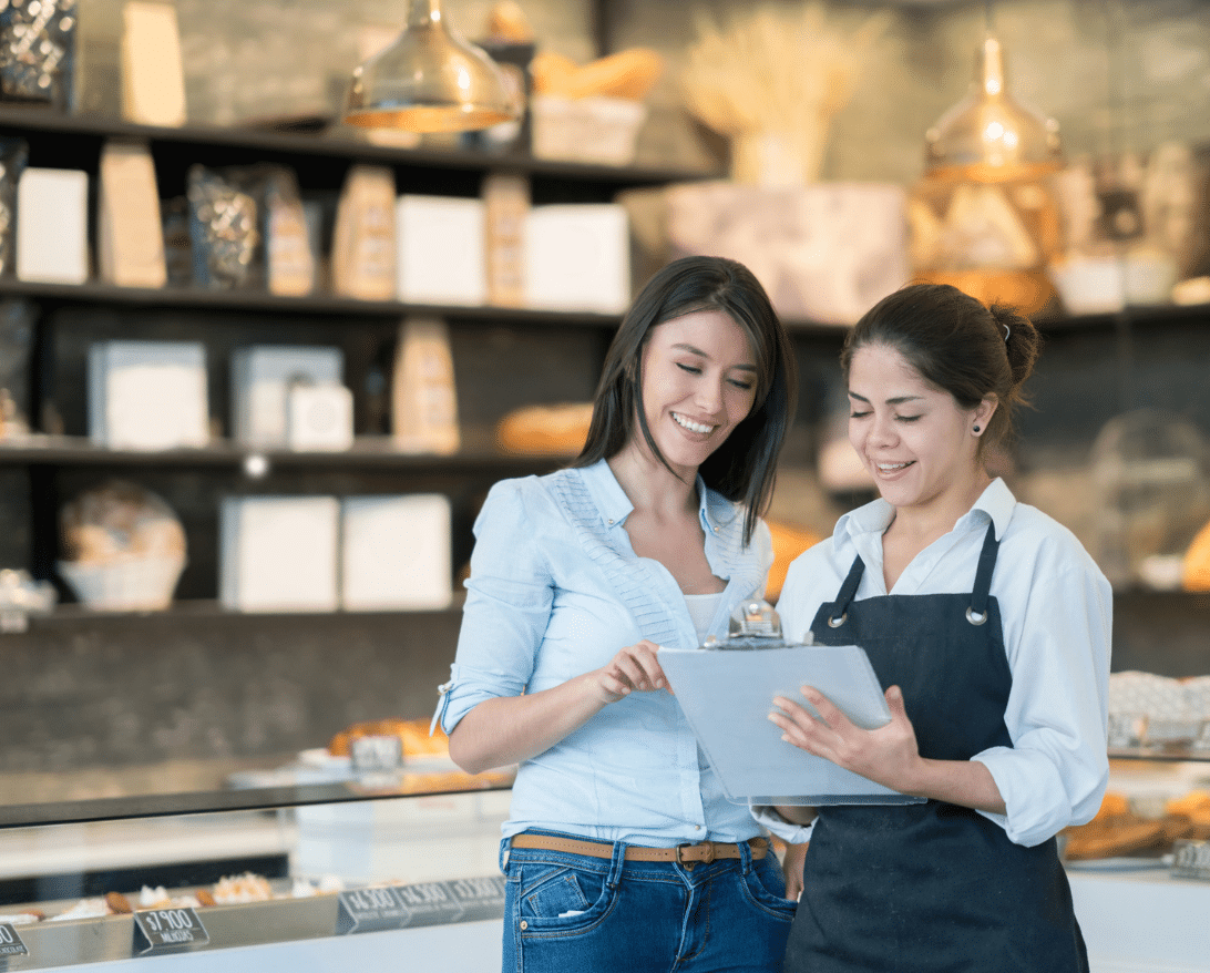 owner and worker looking at ipad and setting up a restaurant promotion