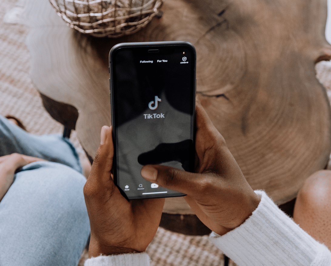 man holding a phone with tiktok on the screen; tiktok ideas for restaurants