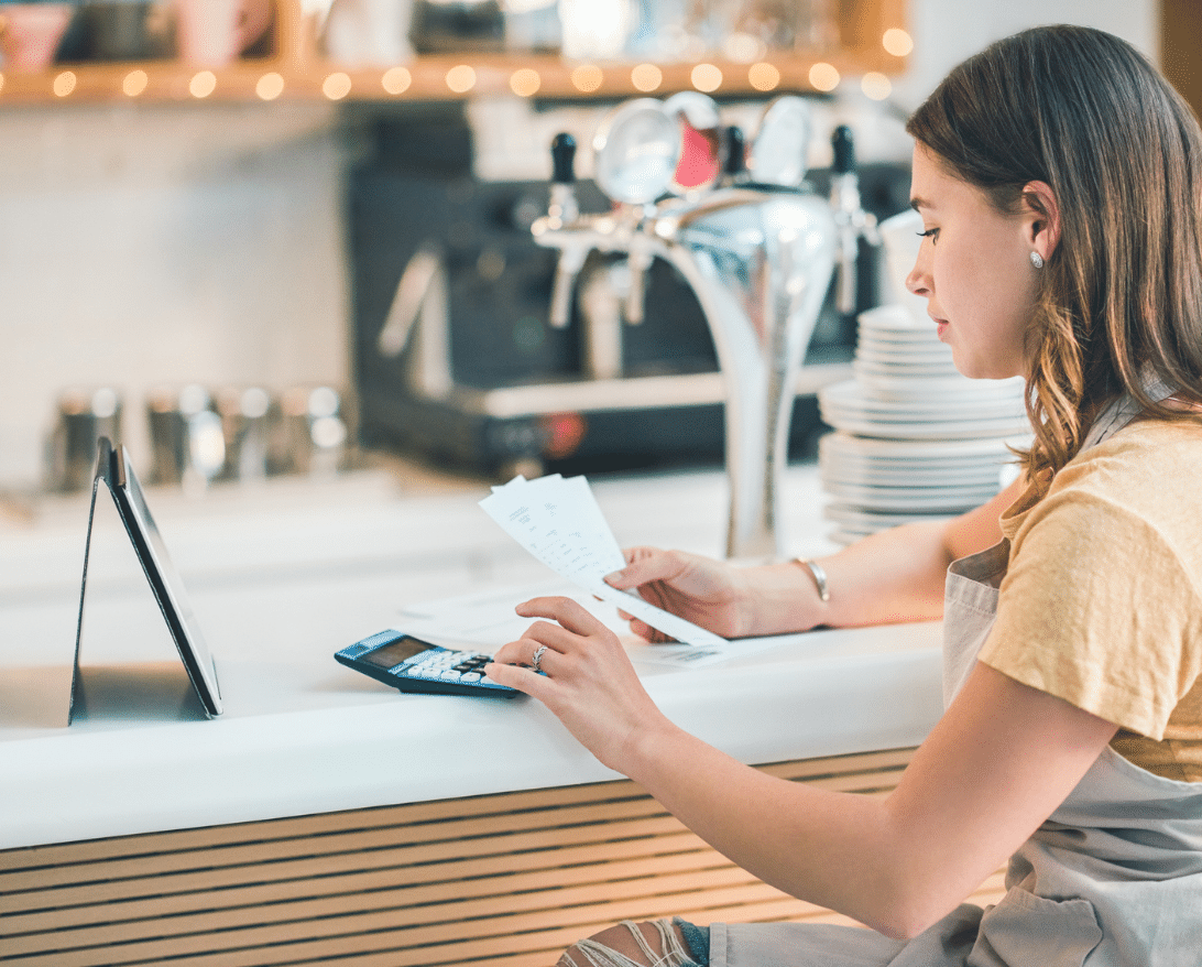 restaurant owner sitting at bar calculating restaurant profit margin