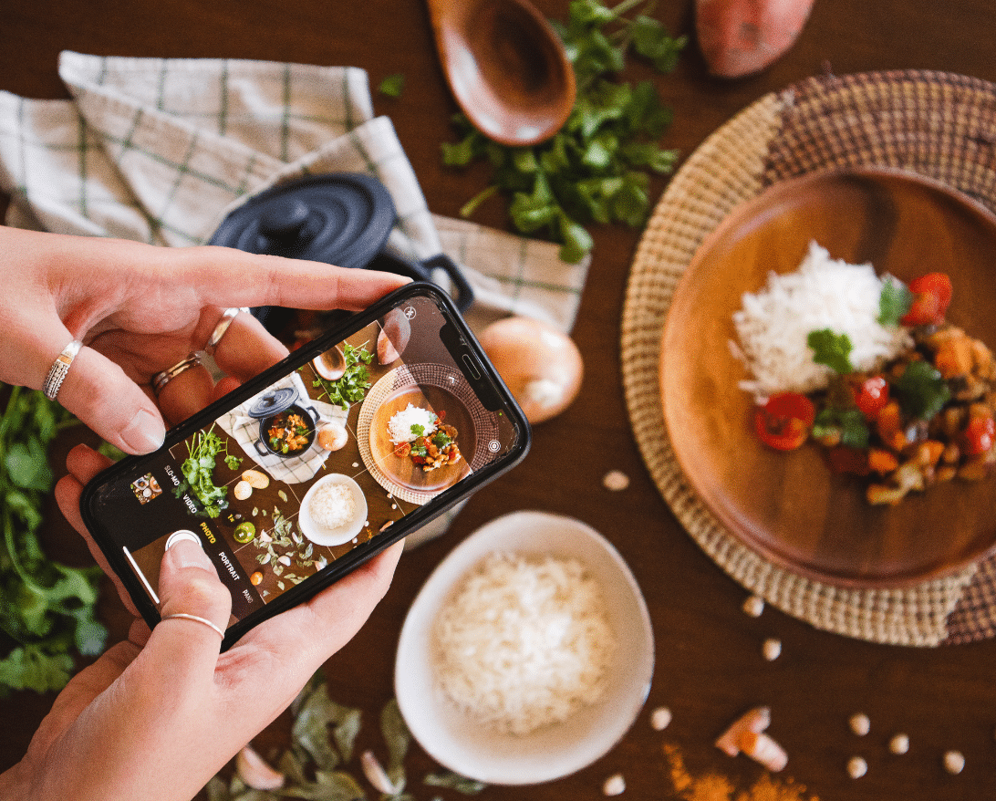 A micro-influencer takes a photo of a restaurant dish.