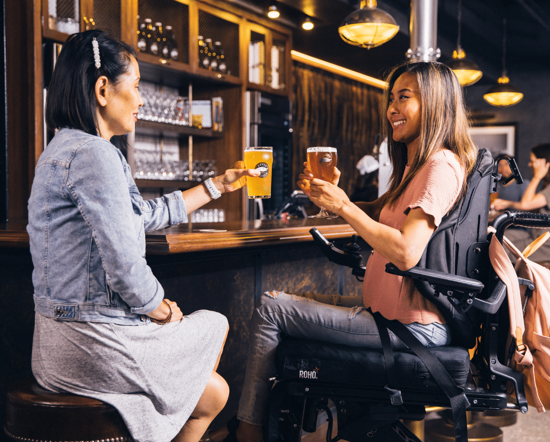 A customer in a wheelchair enjoys a meal at a restaurant.
