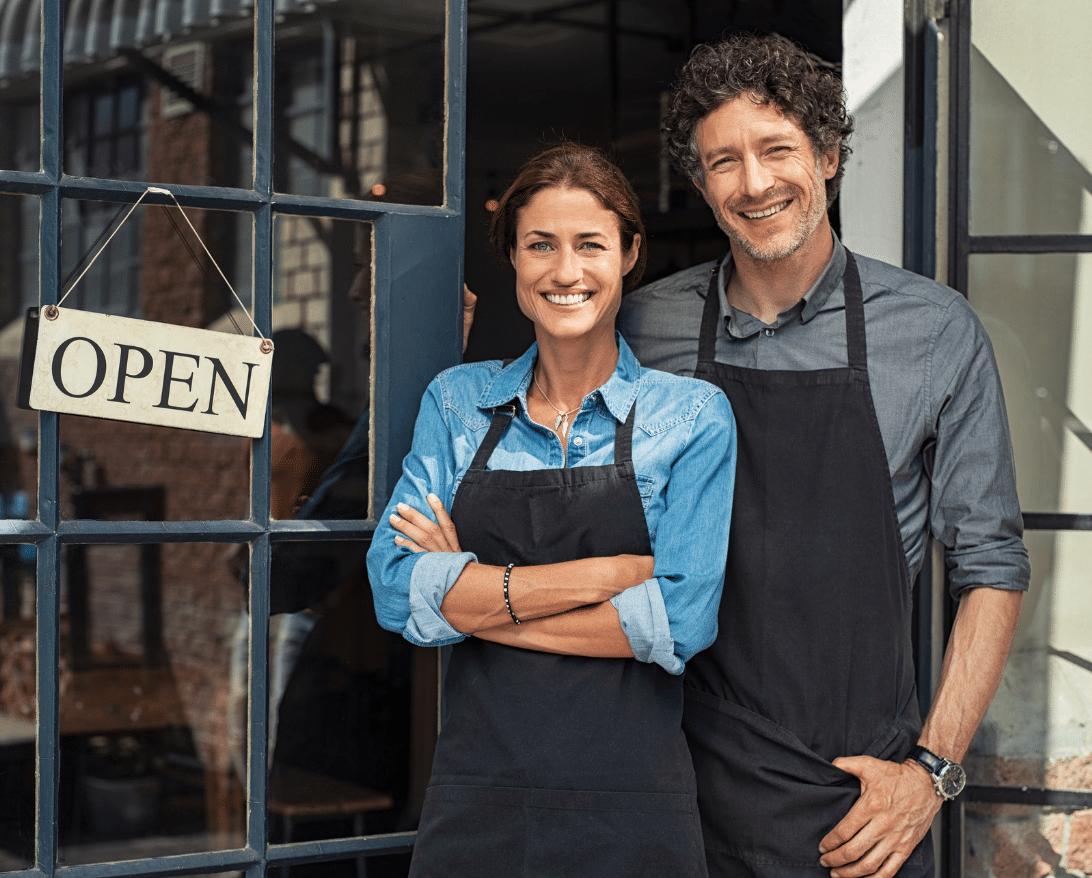 Restaurant owners stand in front of their business