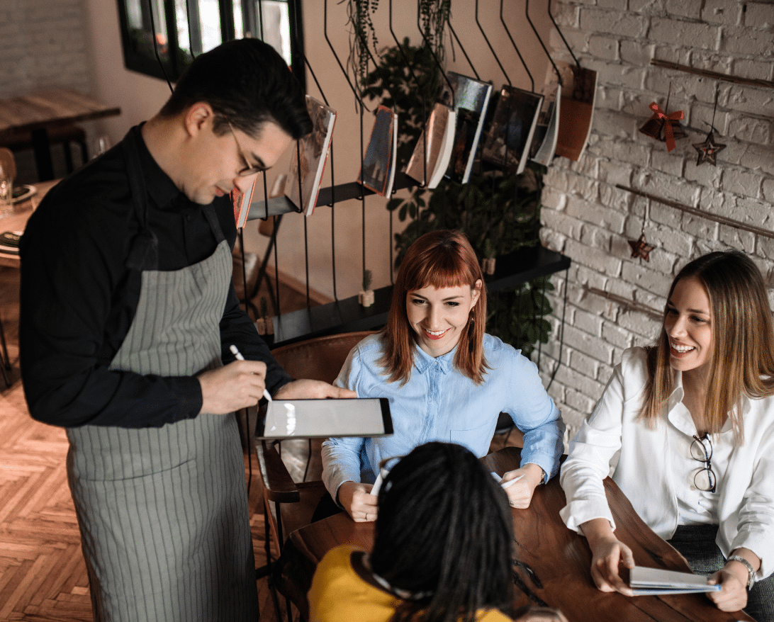 A waiter explains what a service charge is to customers.