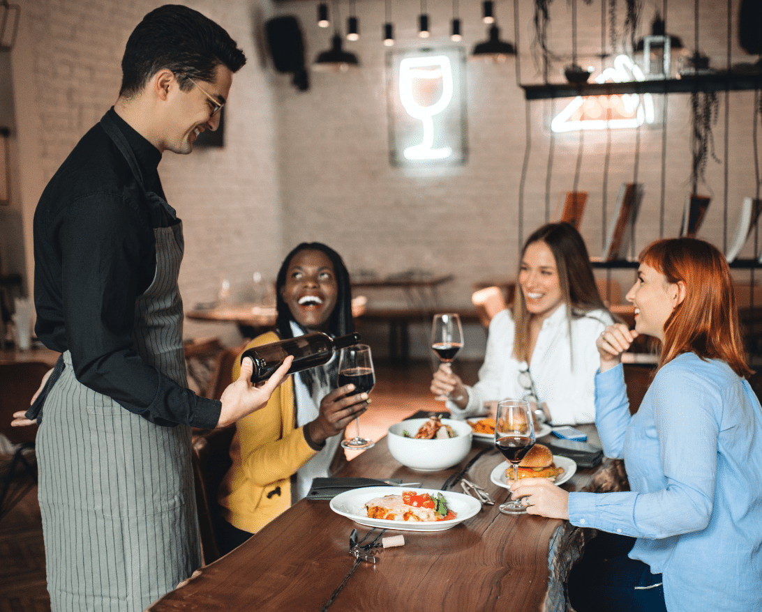 A waiter serves customers at a restaurant