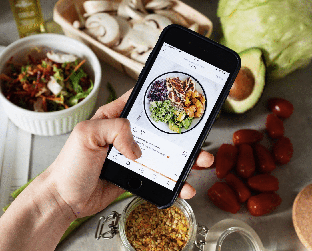 An owner takes a photo for restaurant instagram marketing.